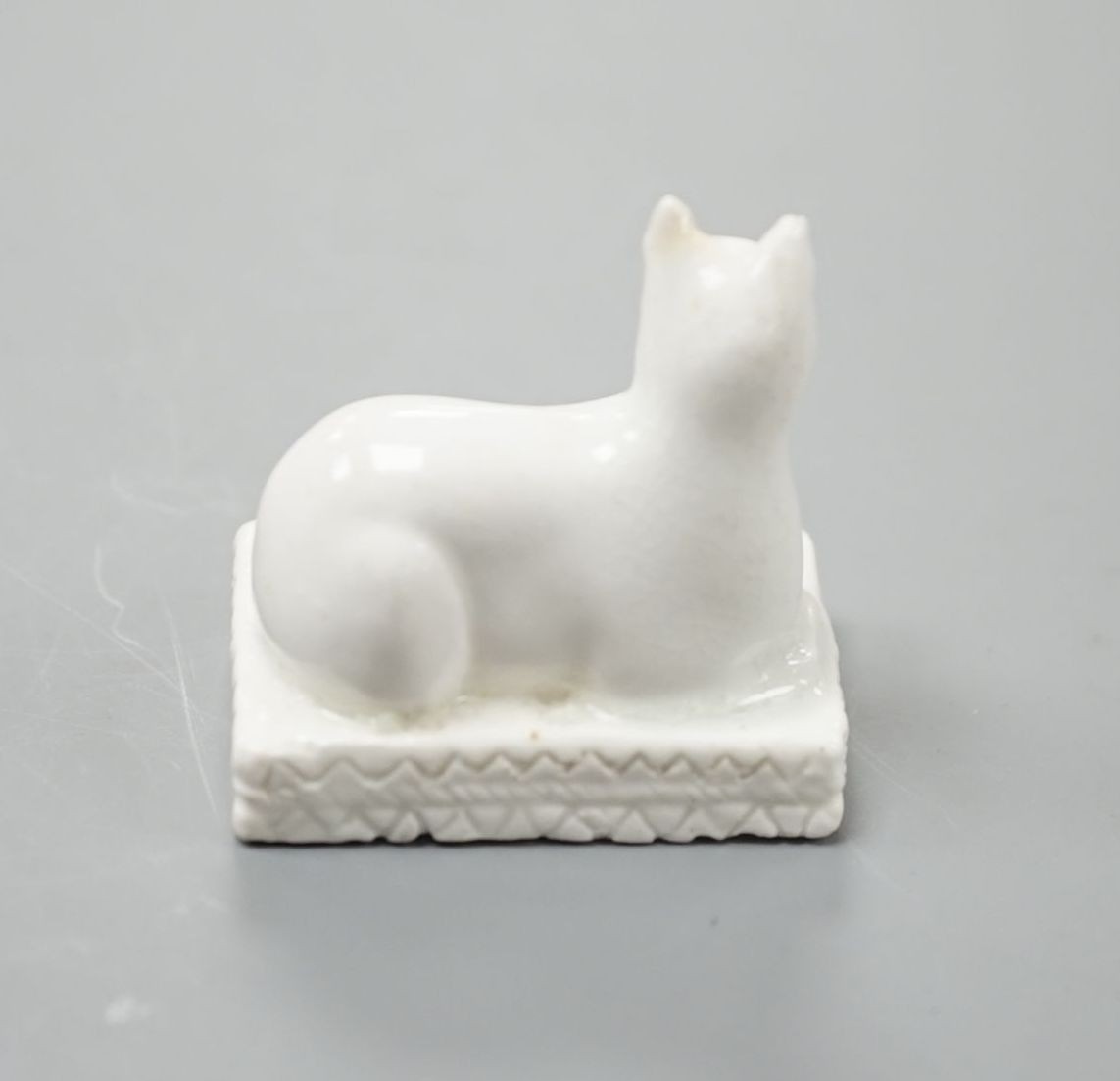 A Derby porcelain model of a cat recumbent on a cushion base, c.1810–25, 3.6 cm long, Cf. Dennis G.Rice, Cats in English porcelain, a variant of colour plate 21., Provenance: Dennis G.Rice collection